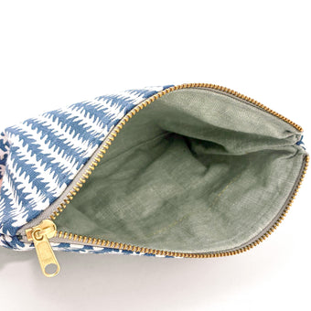 A green interior on this blue and white pattern zip pouch with a gold tone zipper