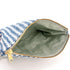 A green interior on this blue and white pattern zip pouch with a gold tone zipper