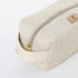 A gold tone zipper and cream luxury leather alternative handle on a beige toiletry kit 