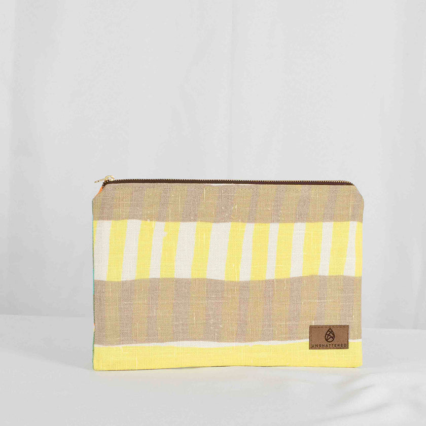 A large zip pouch with yellow and beige stripes and a small brand tag on the bottom right corner.