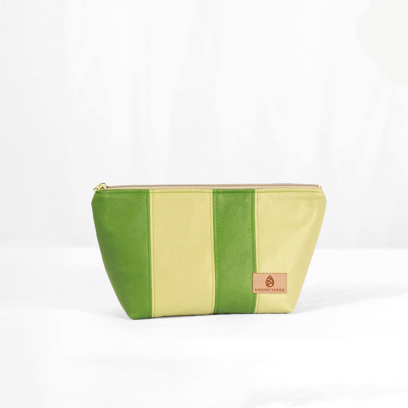 A green multi-panel makeup bag with a zip closure, made from luxury leather alternative material, displayed against a white background named after Gail.