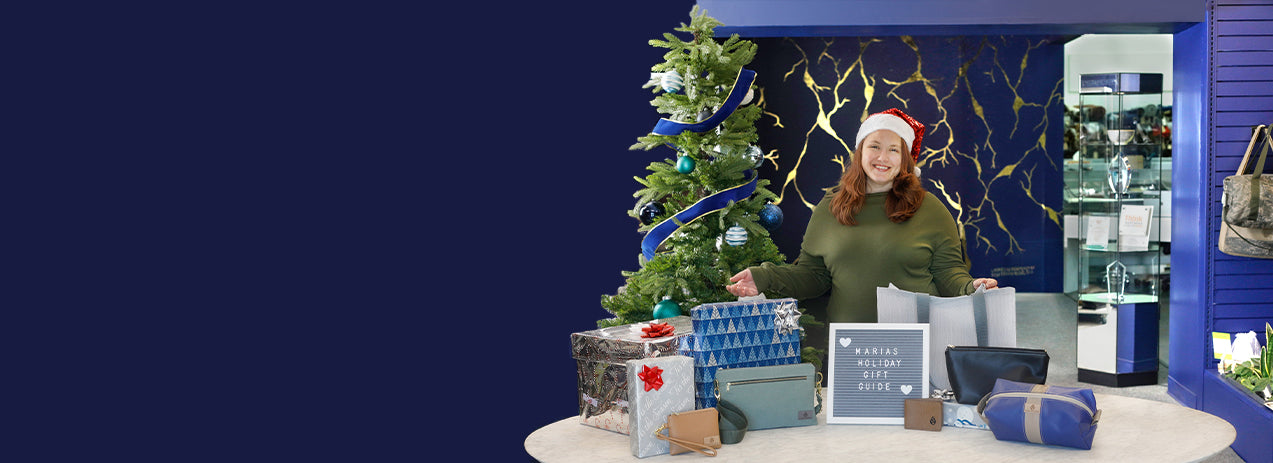 Person in a festive setting with Christmas decorations and gift bags.