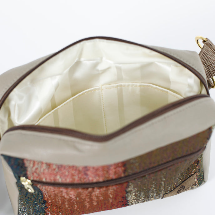 A white striped fabric interior on a fall color errand bag and taupe accents