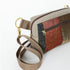 A brown strap with gold hardware on a fall color errand bag and taupe luxury leather alternative accents