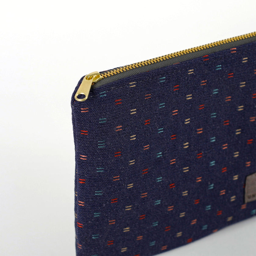A gold tone zipper on an upcycled blue fabric zip pouch named Nancy