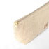 Gold-tone zipper on a makeup bag made from upcycled beige material on a white background