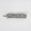 This gray fabric wristlet key clip features a playful dotted pattern and sleek siver-tone hardware.