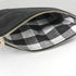 Black zippered pouch with checkered interior on a white background named after Harmony