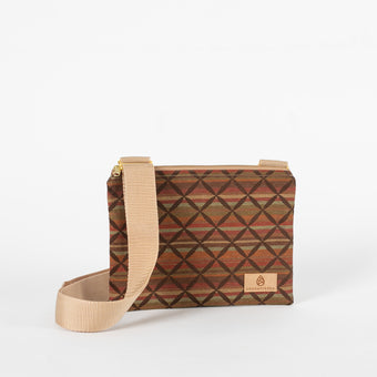 A multicolor fall pattern bag with x across the lined print fabric crossbody bag with a tan Unshattered label
