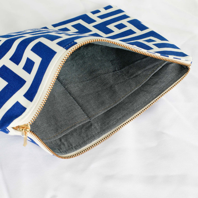 A denim interior on this white and blue design large zip pouch with a gold tone zipper 