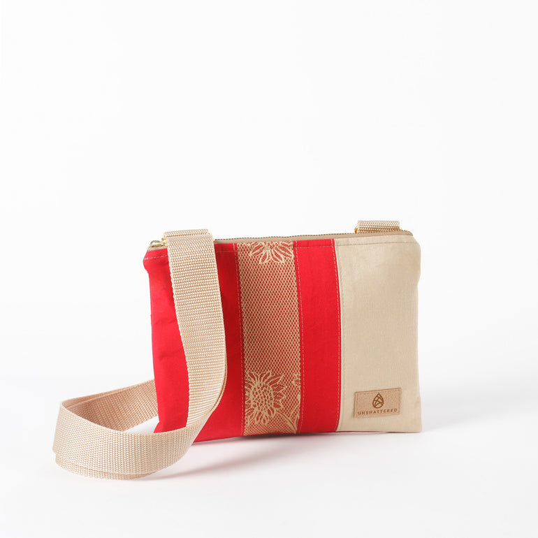 Red and beige multi-panel crossbody bag with a strap on a white background