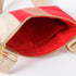 Close-up of a beige and red crossbody with red fabric interior on a white background named after Honey 
