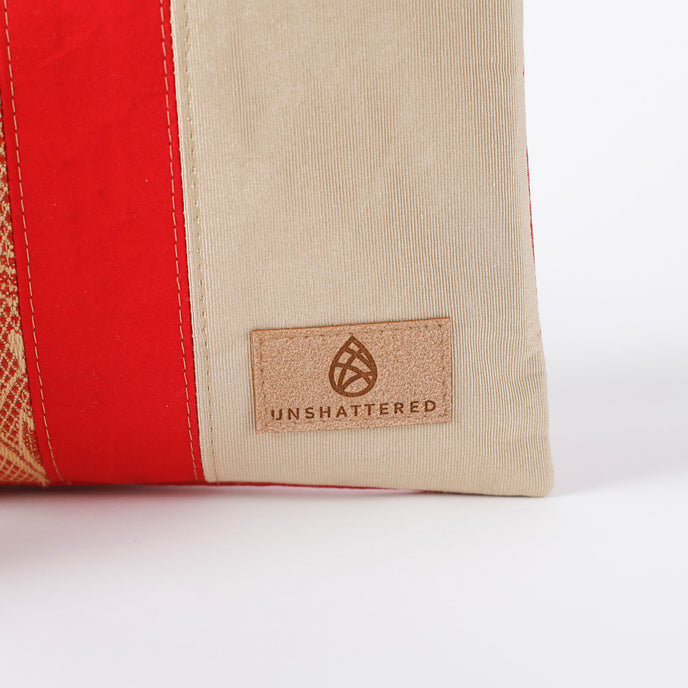Beige and red fabric with 'Unshattered' brand logo on a white background named after Honey 