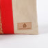 Beige and red fabric with 'Unshattered' brand logo on a white background named after Honey 