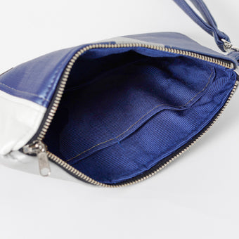 A blue interior with silver zipper on a multi-panel wristlet named after Audrey.