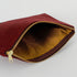 Striped fabric inside a burgundy floral damask fabric pouch can be seen on a white background