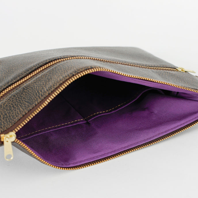Purple fabric interior of brown 3-in-1 bag can be seen on a white background