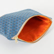 A orange interior fabric with gold seam and a blue shell exterior zip pouch 