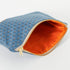 A orange interior fabric with gold seam and a blue shell exterior zip pouch 