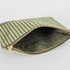 Green fabric interior of a green plush zippered pouch against a gray background
