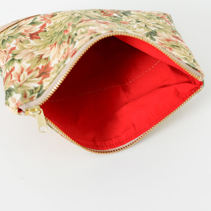 A red interior fabric on a leaf pattern zip pouch named after Lynette