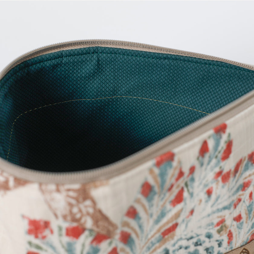 Close-up of a floral-patterned pouch with a hunter green interior named after Tamir 