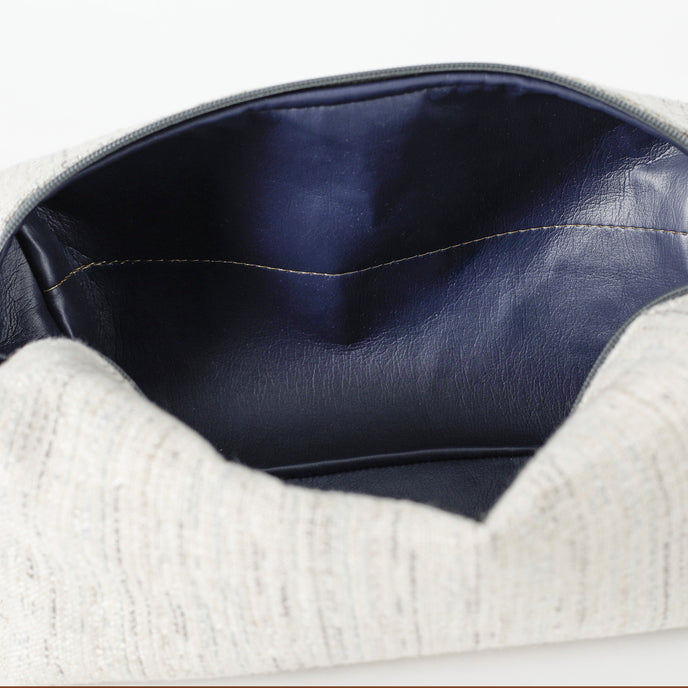 A dark blue wipe-clean interior with a gold seam on a two toned twill weave toiletry kit named after Tasha