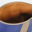 Close-up of a blue and beige leather bag with a brown interior.
