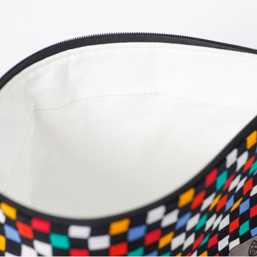 Close-up of a white wipe-clean interior makeup bag with checkered pattern on a white background named after Luisa 