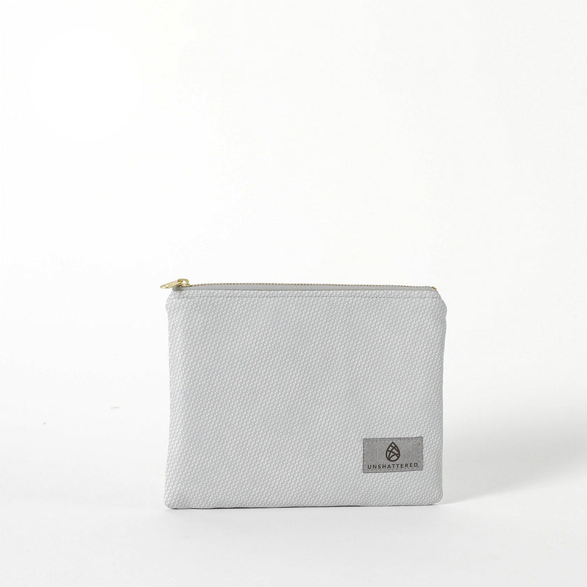 A gray Irene Zip Pouch with a subtle geometric pattern, gold-tone hardware, and a zip closure. The brand's logo is visible on the front.