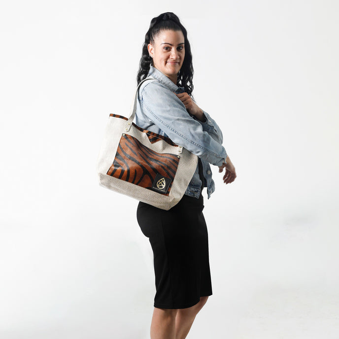 Woman carrying a tote bag with a tiger design on a white background