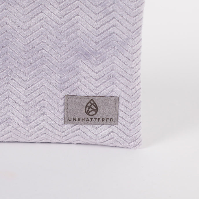 Light purple  textured bag with 'Unshattered' brand label on a white background named after Jaimilee
