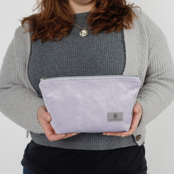 A woman holding a purple plush makeup kit named after Jamar 