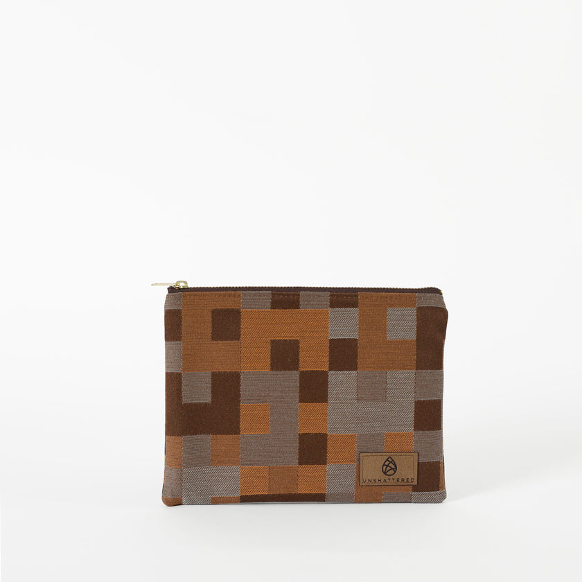A zippered pouch with a modern geometric square pattern in various shades of brown. 