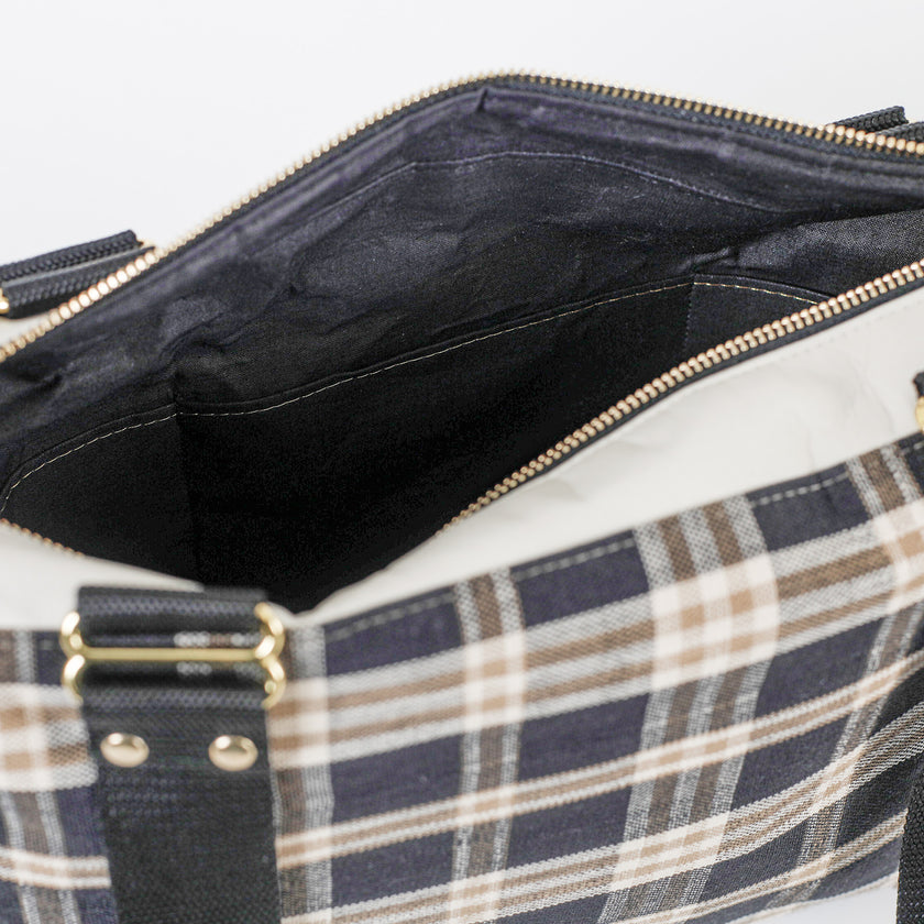Plaid bag with open zipper showing black interior named after Jeanne