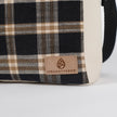 Plaid-patterned bag with 'Unshattered' brand logo on a white background named after Jeanne