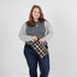 Woman holding a plaid clutch wristlet against a plain background named after Jenny