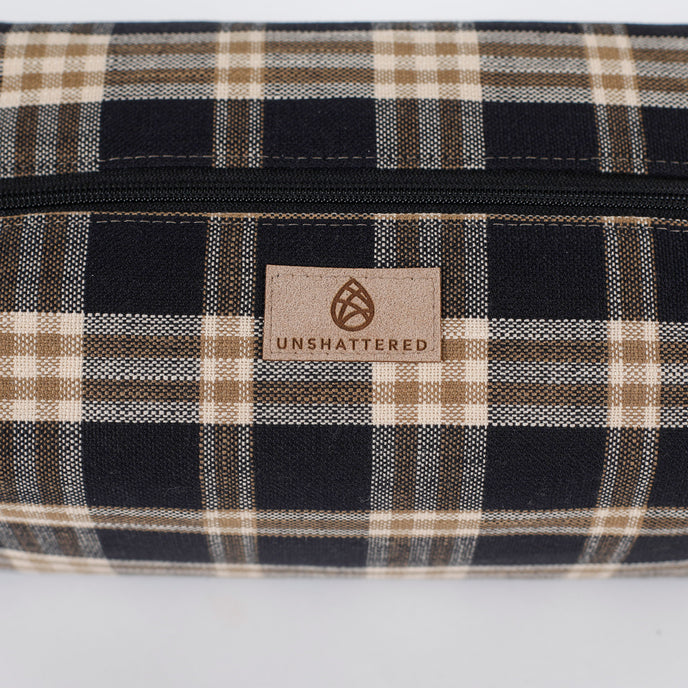 Plaid patterned bag with 'Unshattered' brand logo on a white background named after Jeremiah 