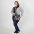 Woman wearing a plaid crossbody bag against a white background named after Jesus