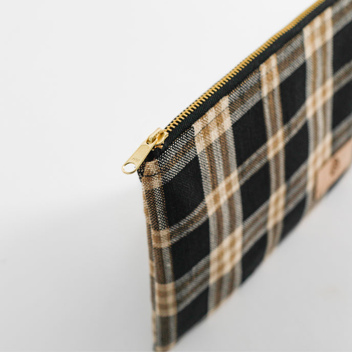 Plaid pouch with gold zipper on a light gray background named after Jeyana