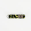 A black fabric with green floral fabric loop keychain with black hardware 