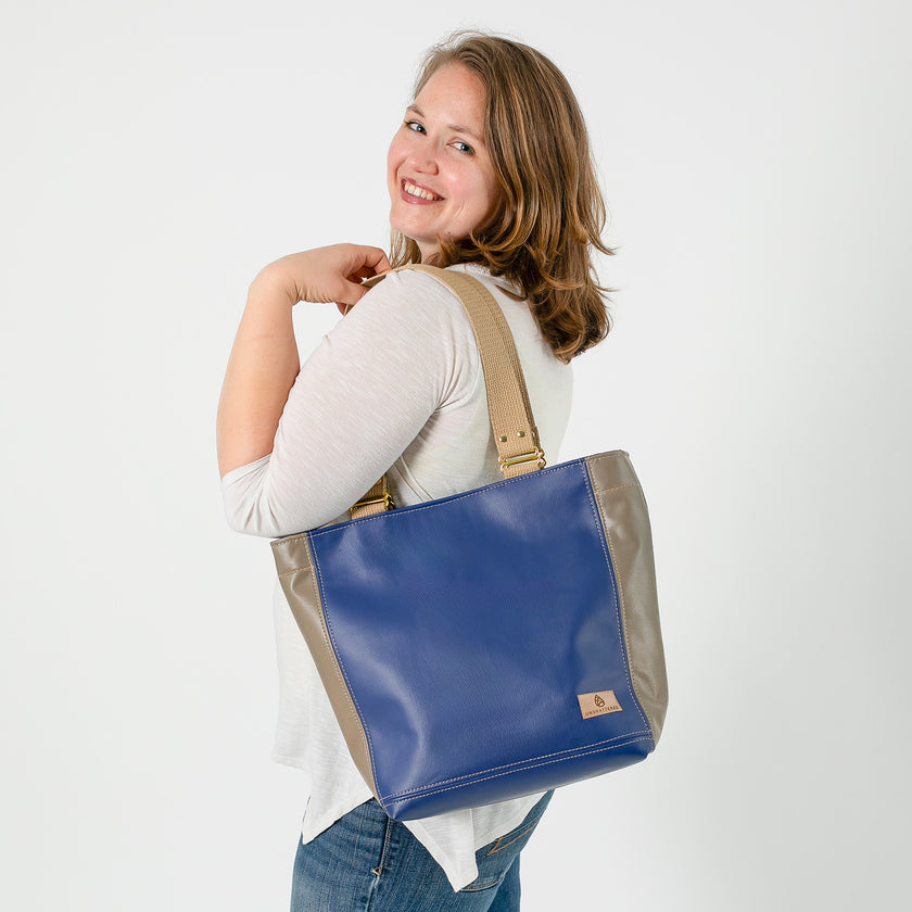 A woman holding a Southwest Tote smiling 