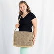 A woman carrying a Douglas large messenger light brown with white circles pattern and a brown label 