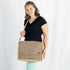 A woman carrying a Douglas large messenger light brown with white circles pattern and a brown label 