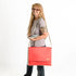 A woman carrying books wearing a red formula e racing material large messenger bag 