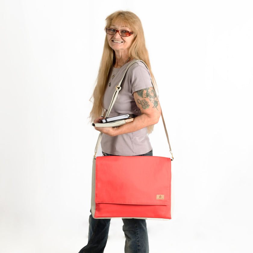 A woman carrying books wearing a red formula e racing material large messenger bag 