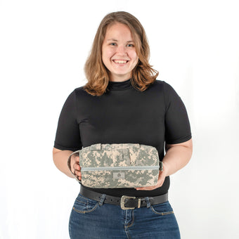 Person holding a camouflage-patterned bag against a white background