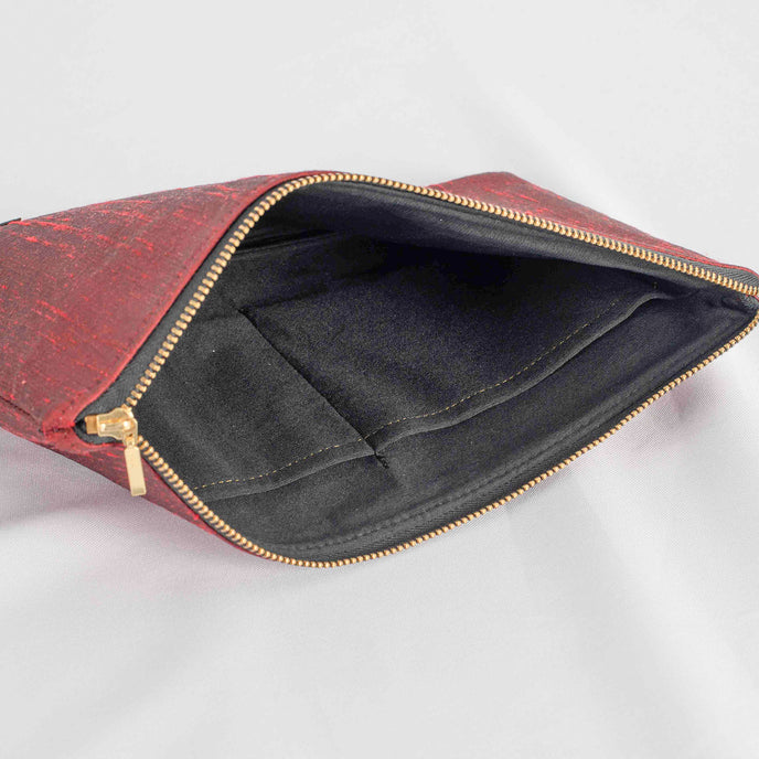 A black interior fabric on this red large zip pouch with gold tone zipper 