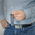 A man holding a Southwest Blue leather keychain with a gold tone hardware 