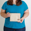 A woman holding a patterned zip pouch named after Karrisha 